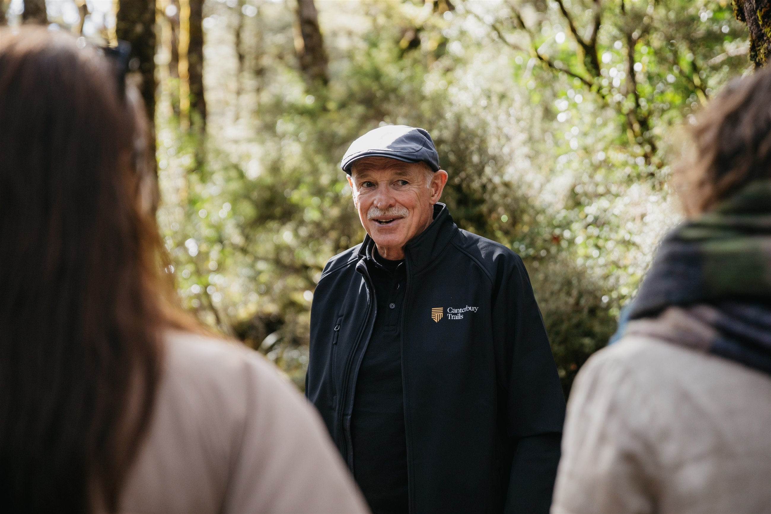 A Canterbury Trails guide talking with two guests on a guided walk at Arthur's Pass