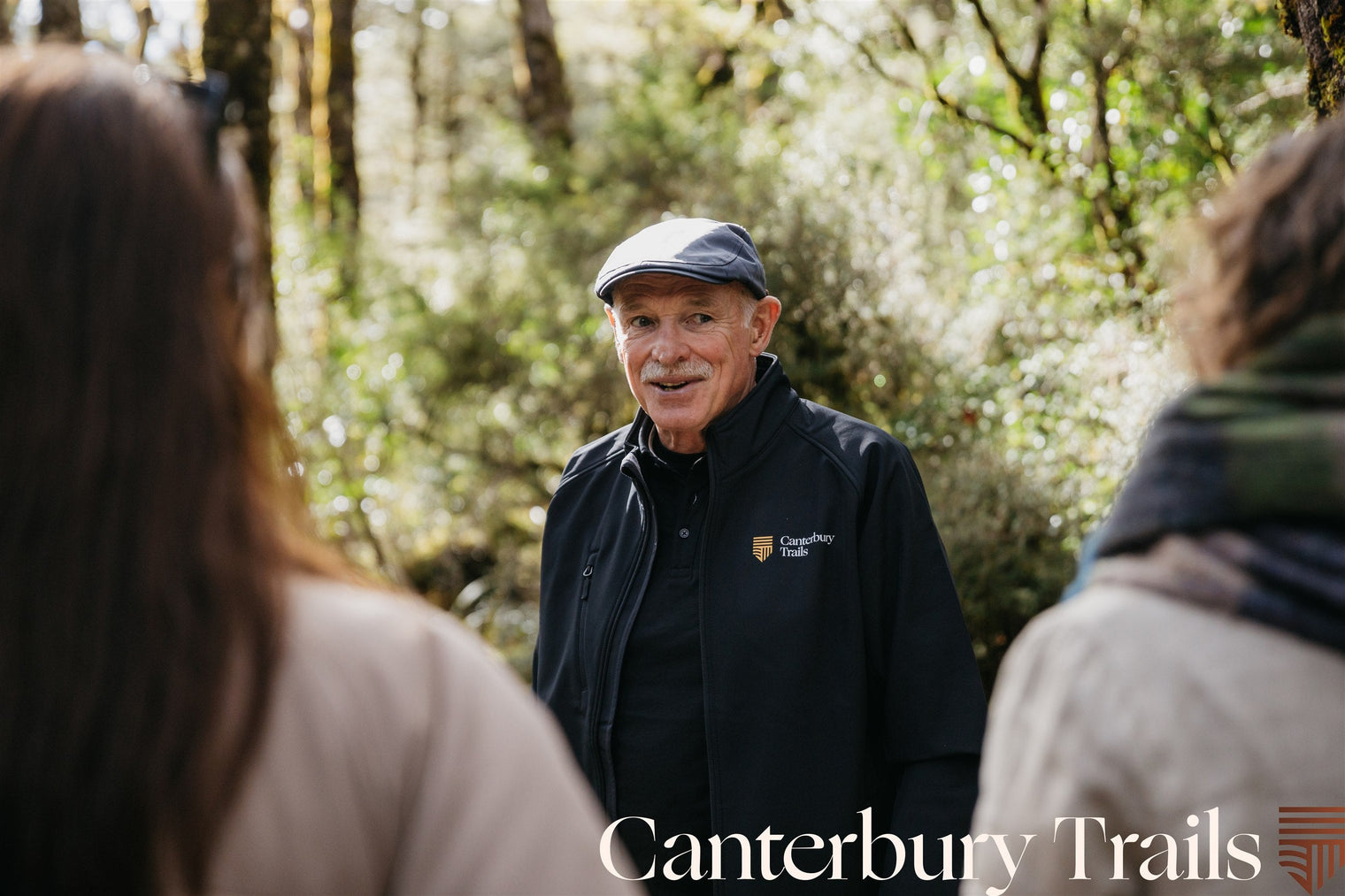 A Canterbury Trails guide talking with two guests on a guided South Island walk