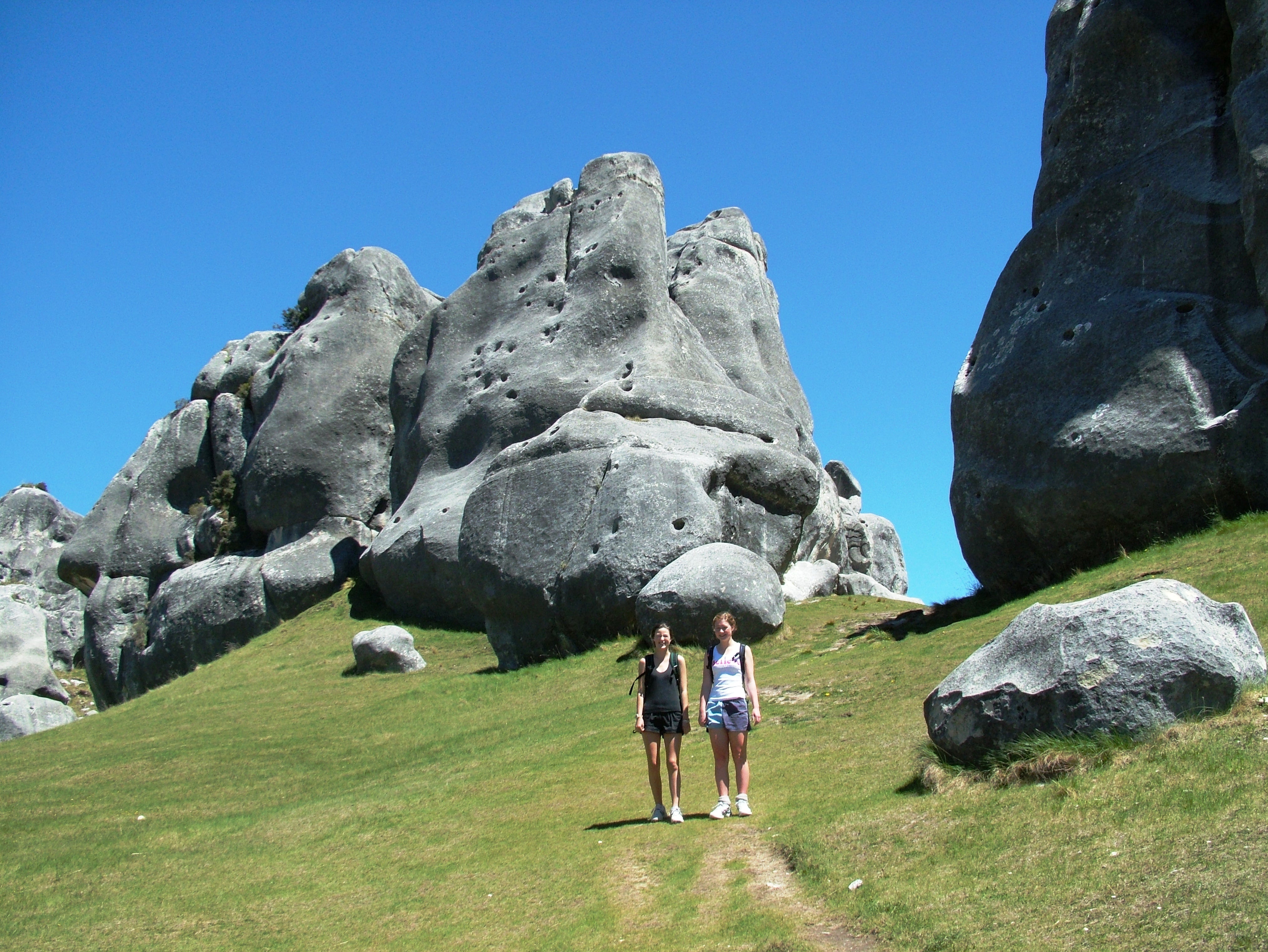 Guests walking among the limestone tors of Kura Tawhiti Castle Hill in Canterbury