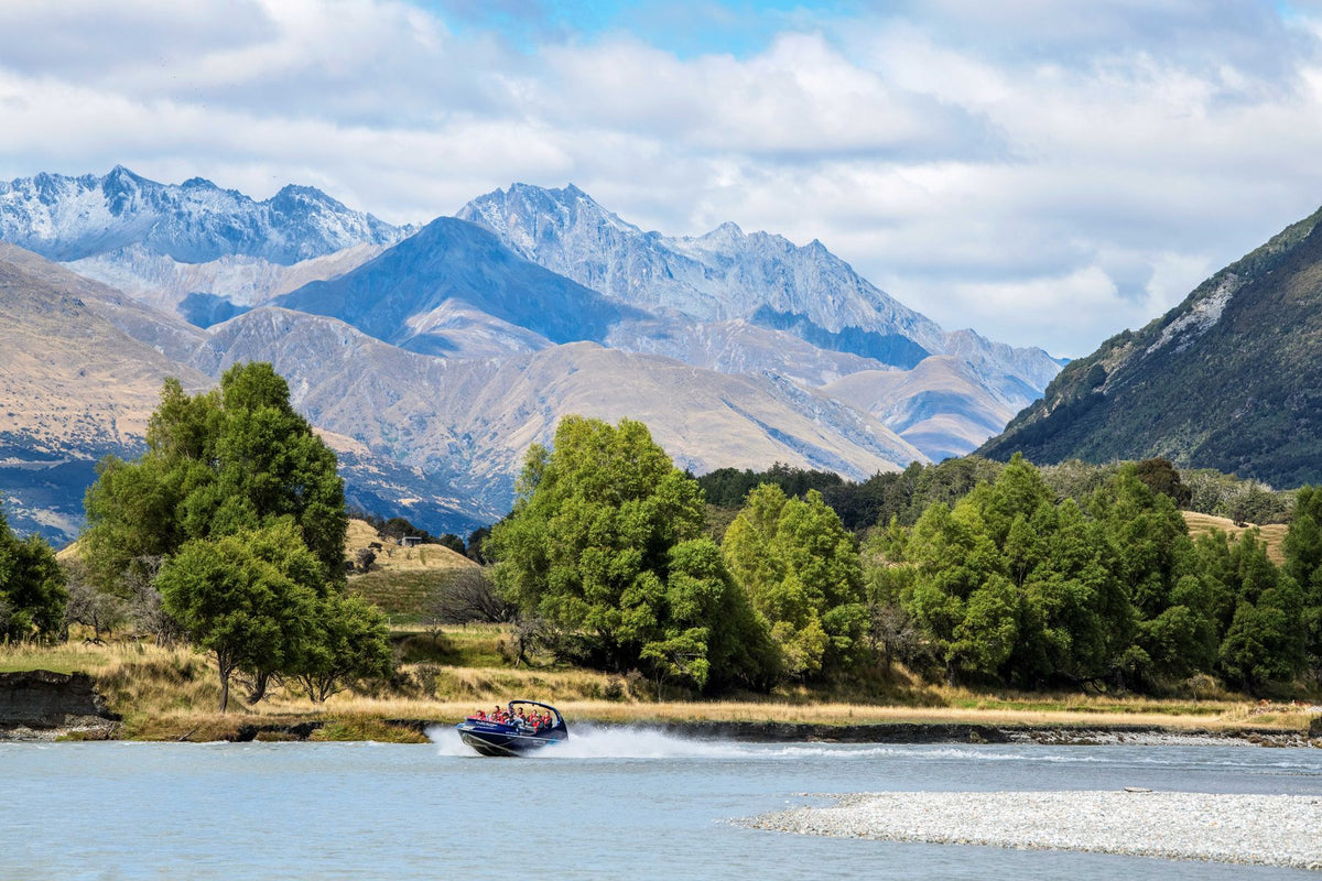 A jet boat on the braided Dart River beneath the mountains