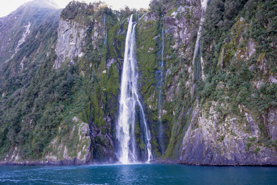 A waterfall plunging down the sheer cliffs of Milford Sound