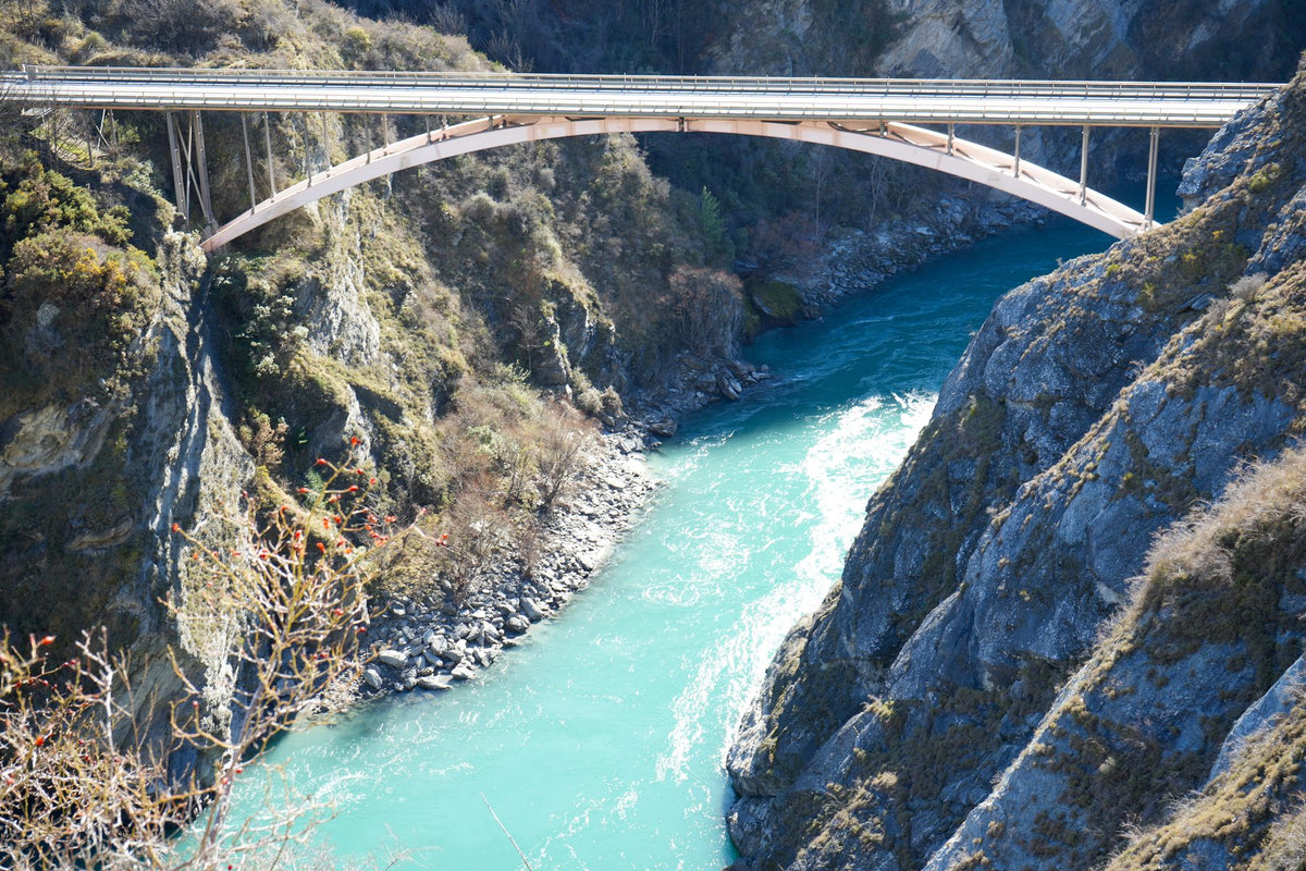 The turquoise Kawarau River running through its gorge beneath a bridge