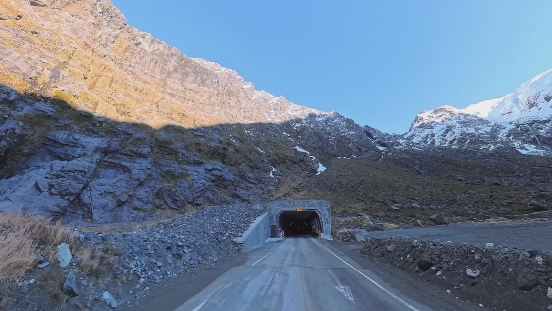 Driving up to the east portal of the Homer Tunnel, with the cirque walls rising above the road